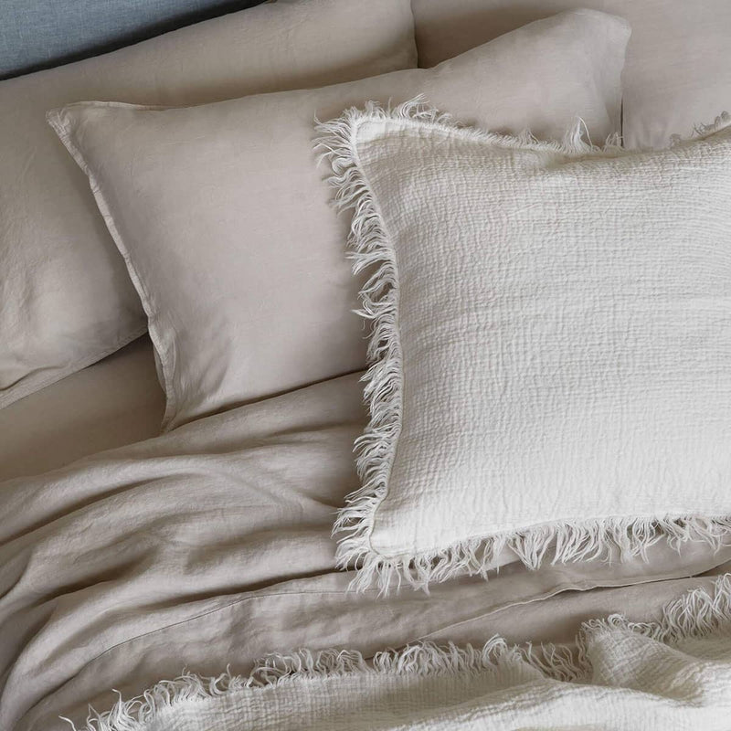 ivory crinkled linen cushion on bed