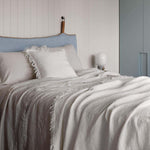 ivory crinkled linen throw rug styled on bed