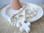 concrete cross and wooden beads on decorative plate