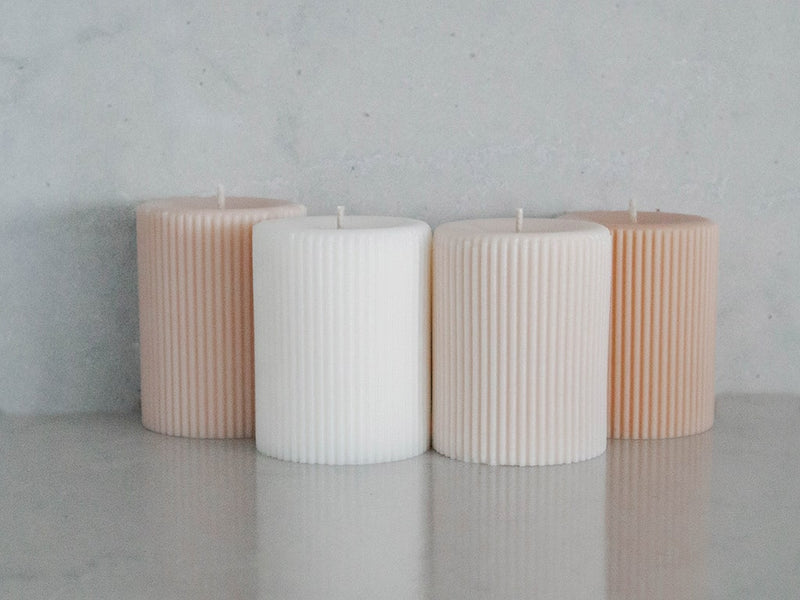 Lined pillar candles four colours on bench