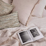 crinkled linen cushion with fringe on bed